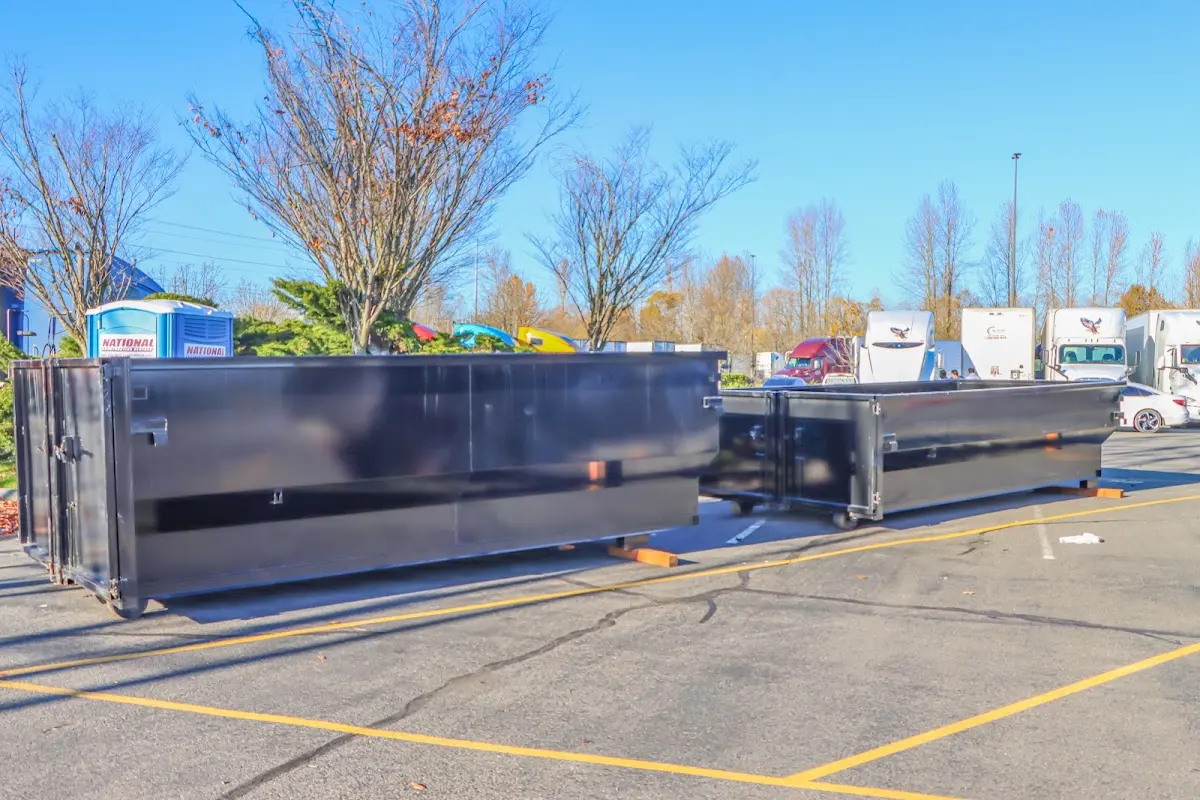 Professional dumpster rental service with roll-off container on residential driveway in Harrington Park